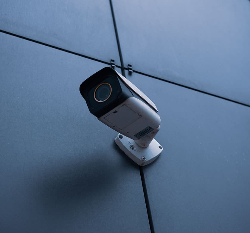 A security camera on a wall. School Security Zeroeyes One uses installed camera for gun violence protection